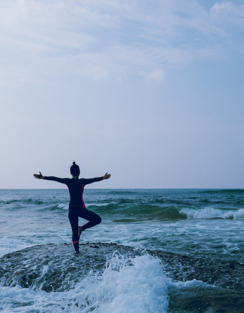 Yoga Lehrerin in einer Pose im Meer